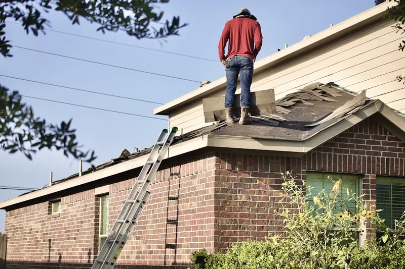 Professional roofer working on a residential roof in Lyle